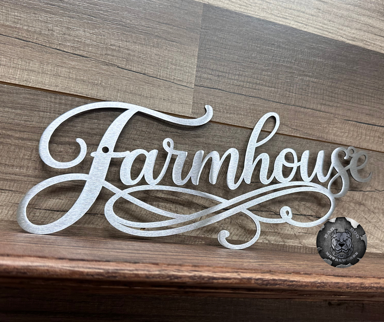 Decorative metal sign with 'Farmhouse' text on a wooden background