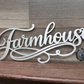 Metal sign with 'Farmhouse' text on a wooden background